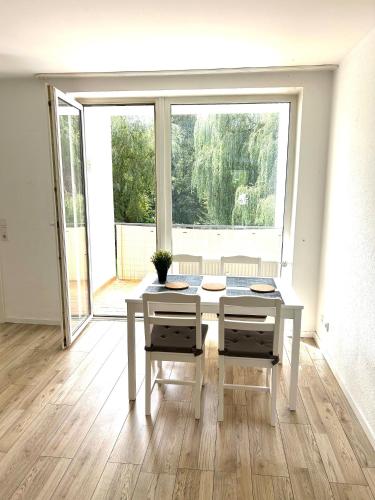a white table and chairs in a room with a large window at Sehr schönes und möbliertes Apartment in Gummersbach