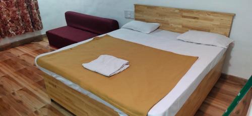 a bedroom with a bed and a red chair at Resort park view kathiyawadi matheran in Matheran
