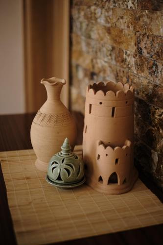a table with vases and a vase on it at Durrat Nizwa Inn in Nizwa