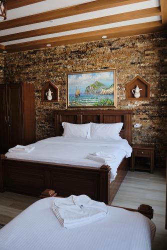 a bedroom with two beds and a brick wall at Durrat Nizwa Inn in Nizwa