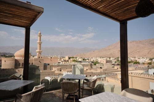 a view of a city from a balcony with tables and chairs at Durrat Nizwa Inn in Nizwa