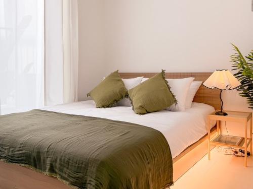 a bed with white sheets and green pillows at Achasan Mountain's Green Forest Han River View a classic 3-room gallery house full of emotions in Seoul