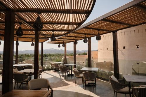 a restaurant with tables and chairs and a view at Durrat Nizwa Inn in Nizwa