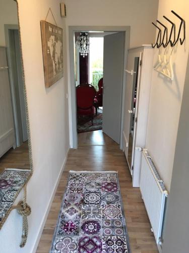 a hallway with a rug on the floor and a mirror at Sehr schönes und möbliertes Apartment in Gummersbach