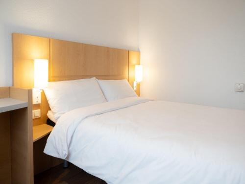 a large white bed in a hotel room at B&B HOTEL Kielce Centrum in Kielce