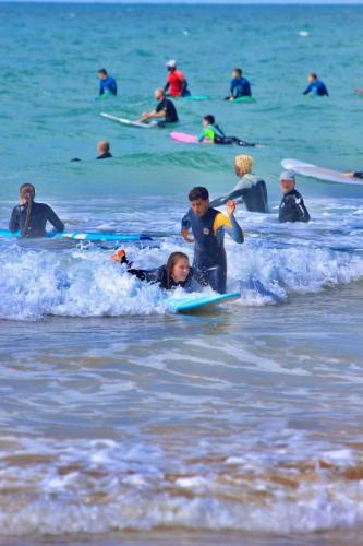 a group of people in the ocean on surfboards at Sable beach surf camp taghazout in Taghazout