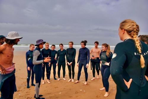 a group of people standing on the beach at Sable beach surf camp taghazout in Taghazout