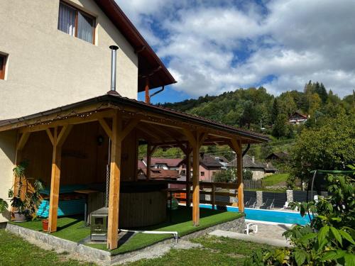 a house with a pavilion next to a swimming pool at Casa Bujor de Munte Dragoslavele in Dragoslavele