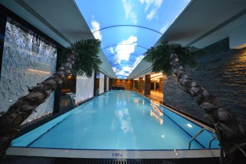 an indoor swimming pool with a glass ceiling at Park Inn by Radisson Ankara Cankaya in Ankara