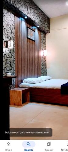 a bedroom with a bed with a wooden wall at Kathiyawadi Resort park view matheran in Matheran