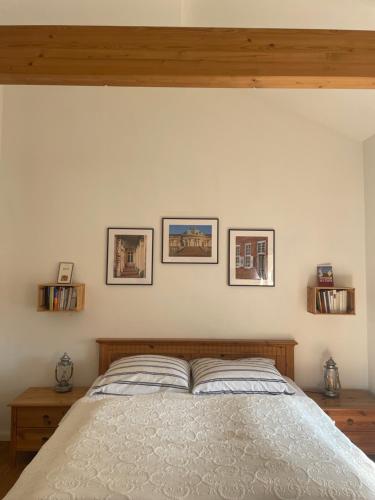 a bedroom with a bed with three pictures on the wall at Seeidyll an der Wublitz in Werder
