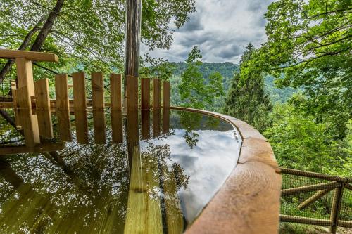 a reflection of the sky in the water on a swinging bridge at Ribno Alpine Glamping in Bled