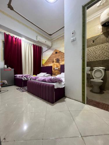 a bedroom with two beds and a toilet at Jana pyramids view in 3 in Cairo