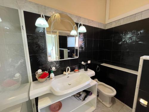 une salle de bain avec un lavabo, des toilettes et un miroir dans l'établissement Imi Beach House, à Agadir nʼ Aït Sa