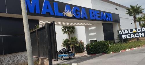 a motorcycle parked outside of a building with a sign at Malaga Beach in Mansouria