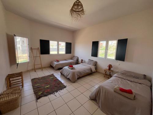 un salon avec deux lits et un canapé dans l'établissement Imi Beach House, à Agadir nʼ Aït Sa