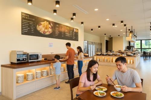 a group of people sitting at a table in a restaurant at 沐舍-蜜滋賀溫泉飯店 in Ruisui