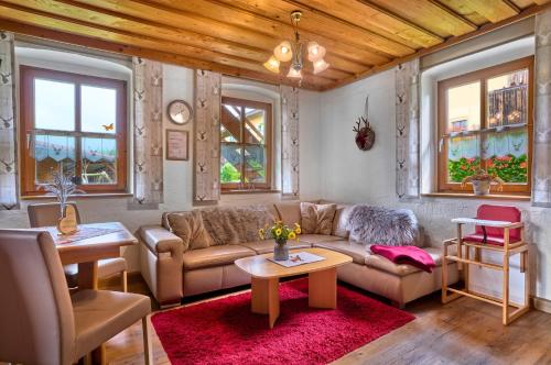 a living room with a couch and tables and windows at Huisnhof in Arrach