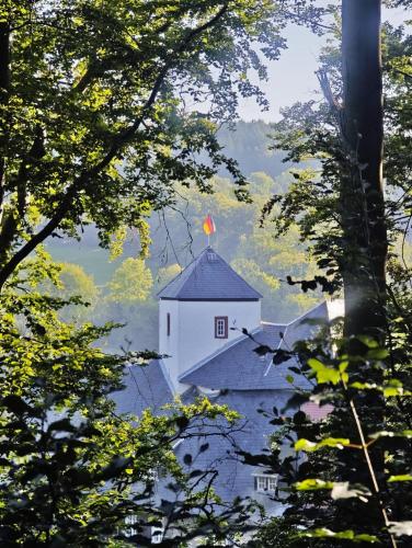 a white building with a flag on top of it at Alte Bleiche Lengefeld in Lengefeld