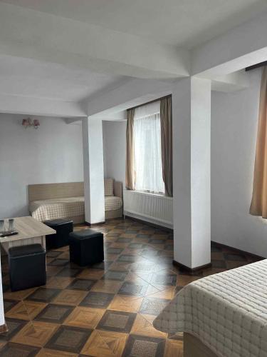 a hotel room with a bed and a table at Къща за гости Динас in Zmeitsa