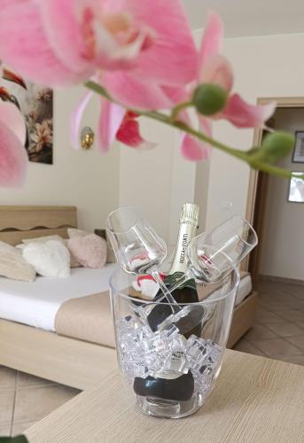 Un jarrón con copas de vino y una flor sobre una mesa. en Domus REA, en Bracciano