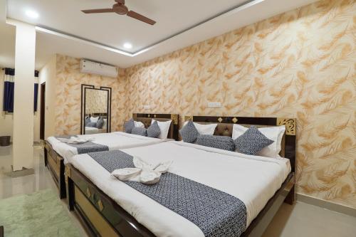 a bedroom with two beds and a ceiling fan at Hotel Galaxy Park in Shamshabad