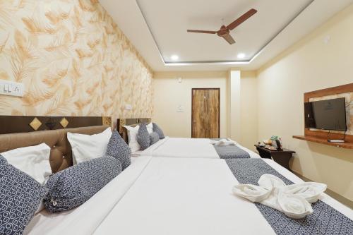 a bedroom with a large white bed and a tv at Hotel Galaxy Park in Shamshabad