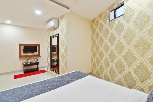 a bedroom with a bed and a tv on a wall at Hotel Galaxy Park in Shamshabad