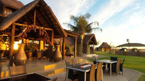 a restaurant with tables and chairs in front of a building at Lapa Lange Game Lodge in Mariental