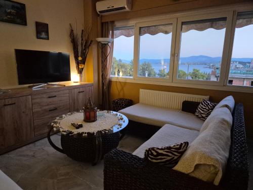 a living room with a couch and a tv at MarlenKay in Chalkida