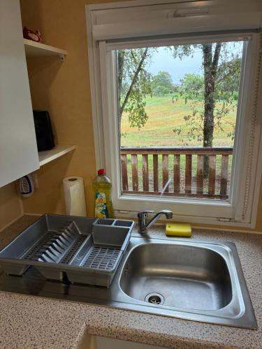 a kitchen sink with a window looking out at a field at La Rosée du Cardou in Gavaudun