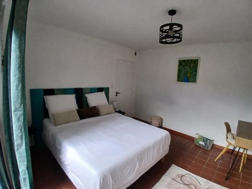 a bedroom with a large white bed in a room at Appartement Atypique Corbières in Montséret