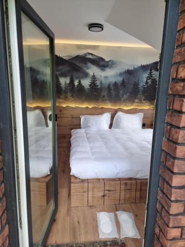 a bed in a room with a painting on the wall at Where Luxury meets Nature !!! in Peje