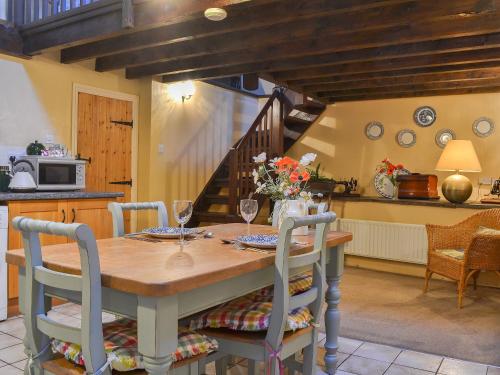 a kitchen and dining room with a wooden table and chairs at Birkerthwaite Barn-W41478 in Eskdale