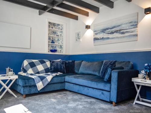 ein blaues Wohnzimmer mit einem blauen Sofa in der Unterkunft Heart Stone Cottage in Staithes