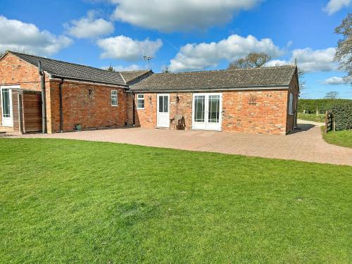 a brick house with a green lawn in front of it at Cherry - Uk49174 in Burgh le Marsh