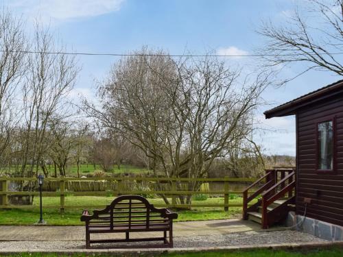 a bench in a park next to a building at Woodpecker Lodge - Uk49149 in Little Singleton