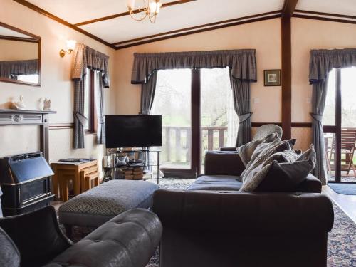 a living room with a couch and a tv at Woodpecker Lodge - Uk49149 in Little Singleton