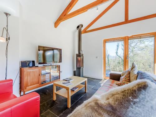 a living room with a red couch and a table at Pyllaubach in Llandeilo