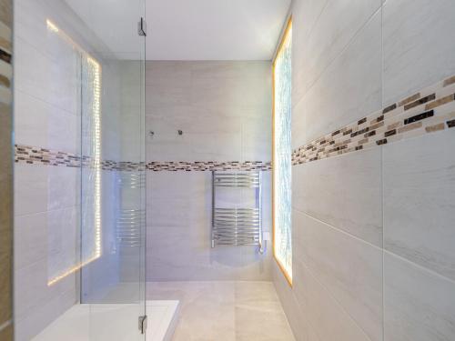 a bathroom with a walk in shower and a glass door at Pyllaubach in Llandeilo