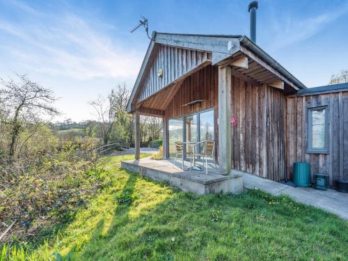 a small wooden house with a porch on a field at Pyllaubach in Llandeilo