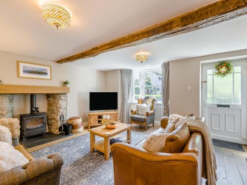 a living room with furniture and a fireplace at Barngarth in Cartmel