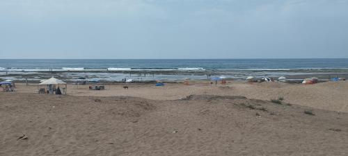 a group of people on a beach with umbrellas at Malaga Beach in Mansouria