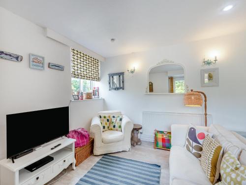 a living room with a tv and a couch at Gamekeepers Hide in Ivybridge