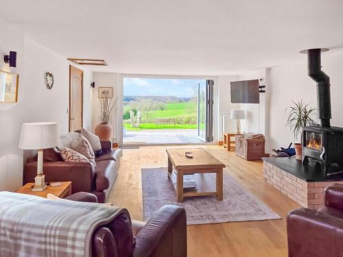 a living room with a couch and a fireplace at Poplars Cottage in Usk