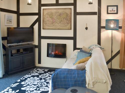 a living room with a couch and a fireplace at The Snug in Amlwch