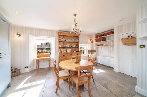 a dining room with a wooden table and chairs at Thrums Cottage in Kirriemuir
