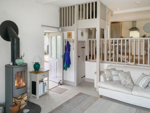 een woonkamer met een bank en een open haard bij Woodlands View in Thorncombe
