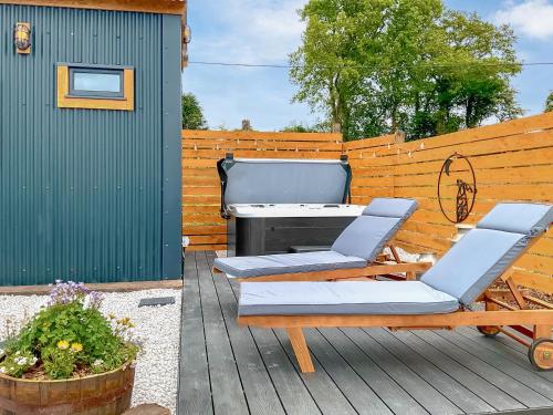 a patio with two chairs and a grill on a deck at Walkeridge Farm in Reading