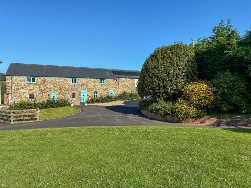 une grande maison en briques avec une allée devant dans l'établissement Beech Cottage - Uk49211, à Jacobstowe